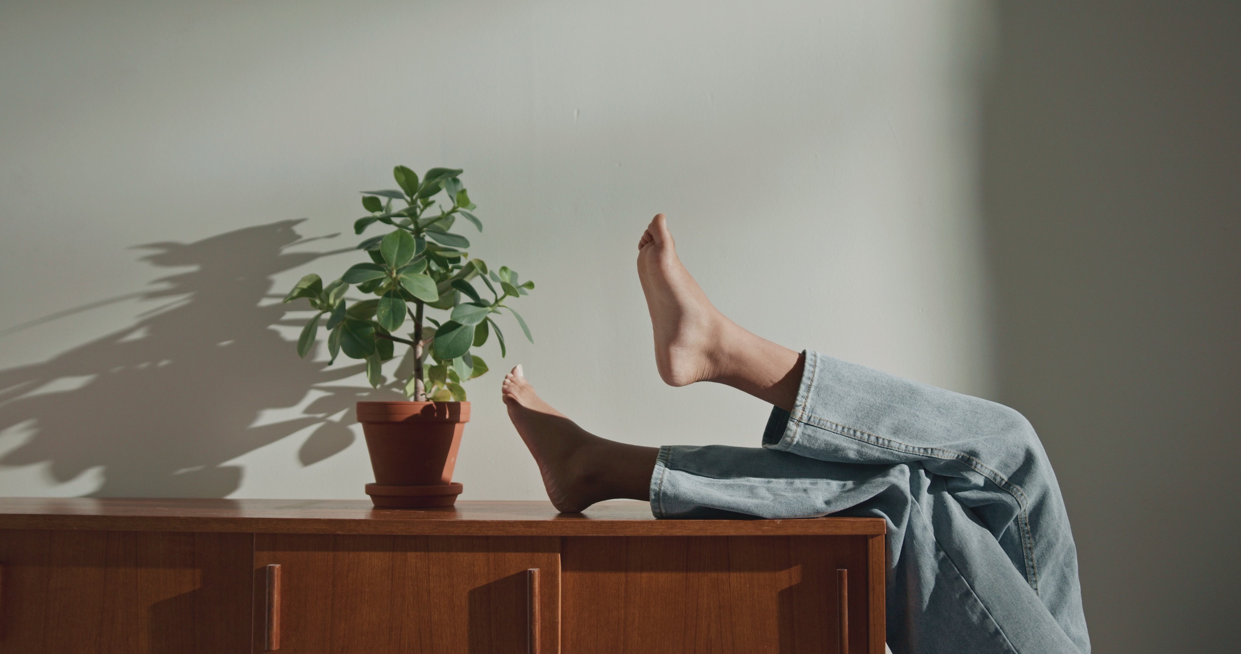 Load video: Feet moving to high fidelity sound and perched on a wooden cabinet